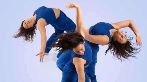 Dancer dressed in blue captured in 3 different poses overlaid on top of each other